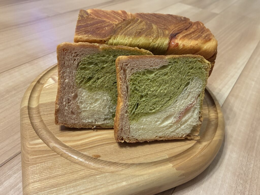 GRAND MARBLEのマーブル食パンの断面。抹茶の緑とイチゴのピンクの層が見える
