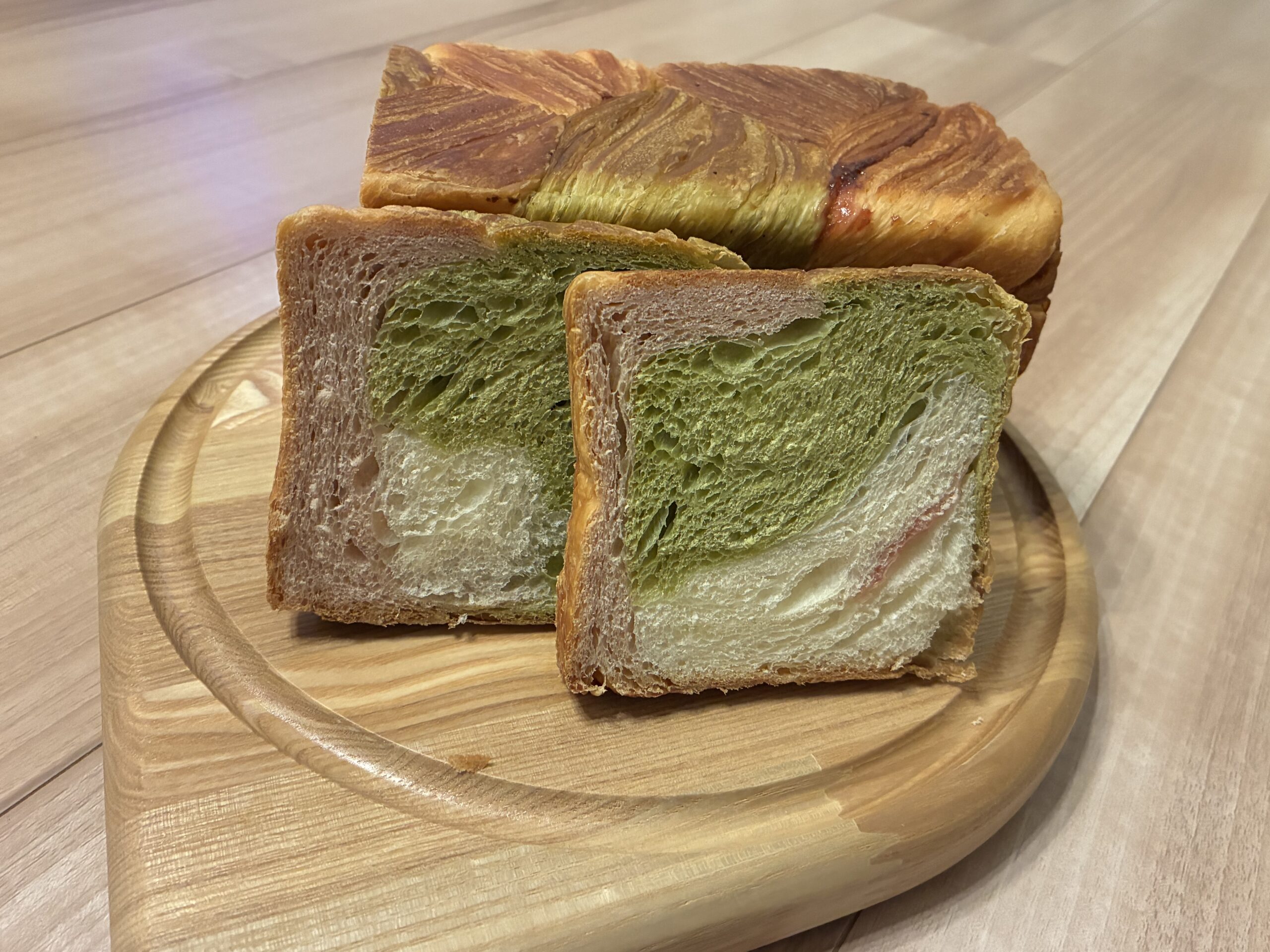 GRAND MARBLEのマーブル食パンの断面。抹茶の緑とイチゴのピンクの層が見える