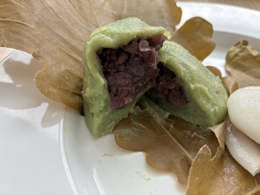 割った粒あんの柏餅。緑色の草餅と粒あん