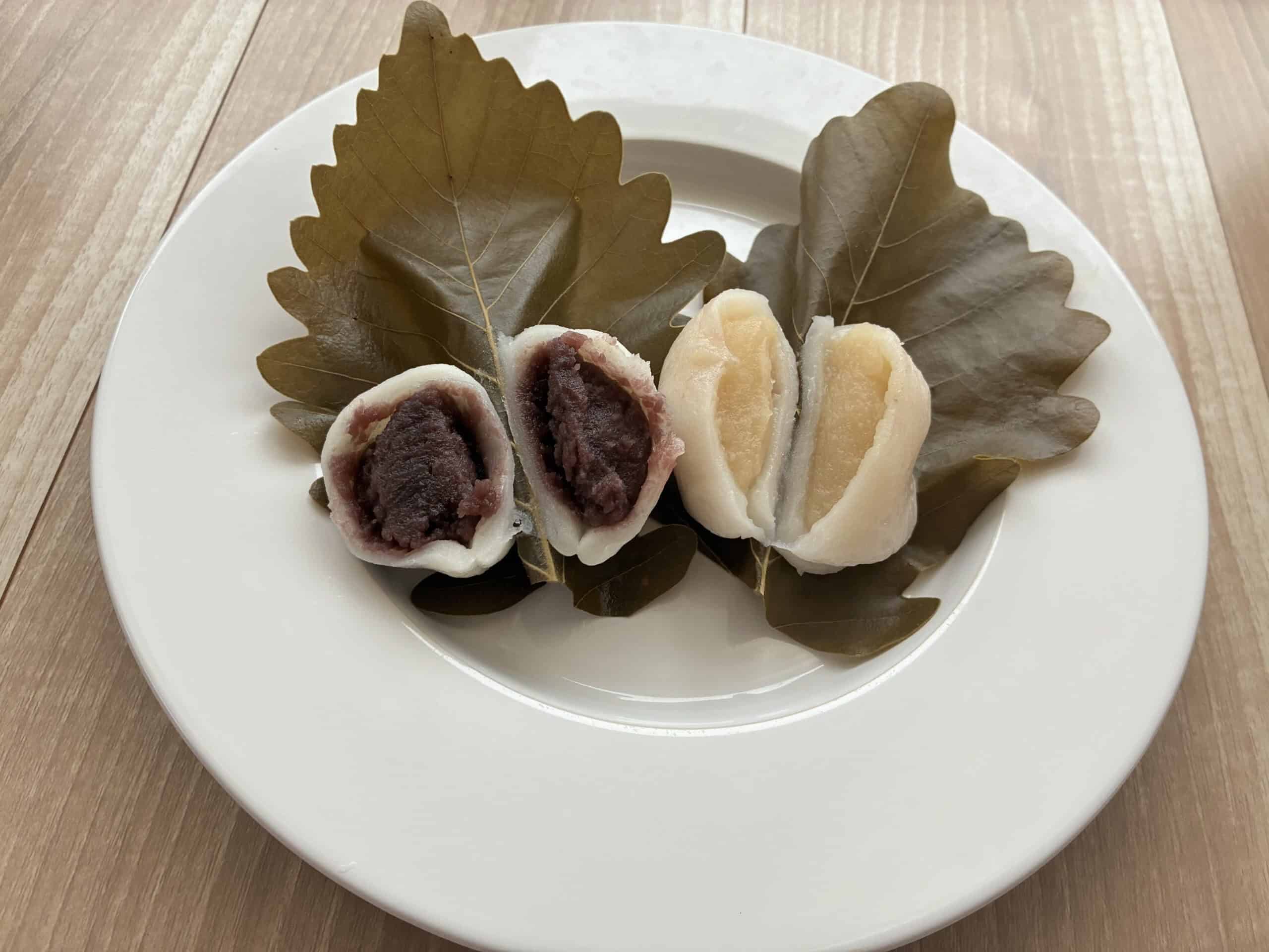 白金高輪・玉川屋 惣八の柏餅。粒あんと白あんの2種を切った断面が柏の葉に乗っている