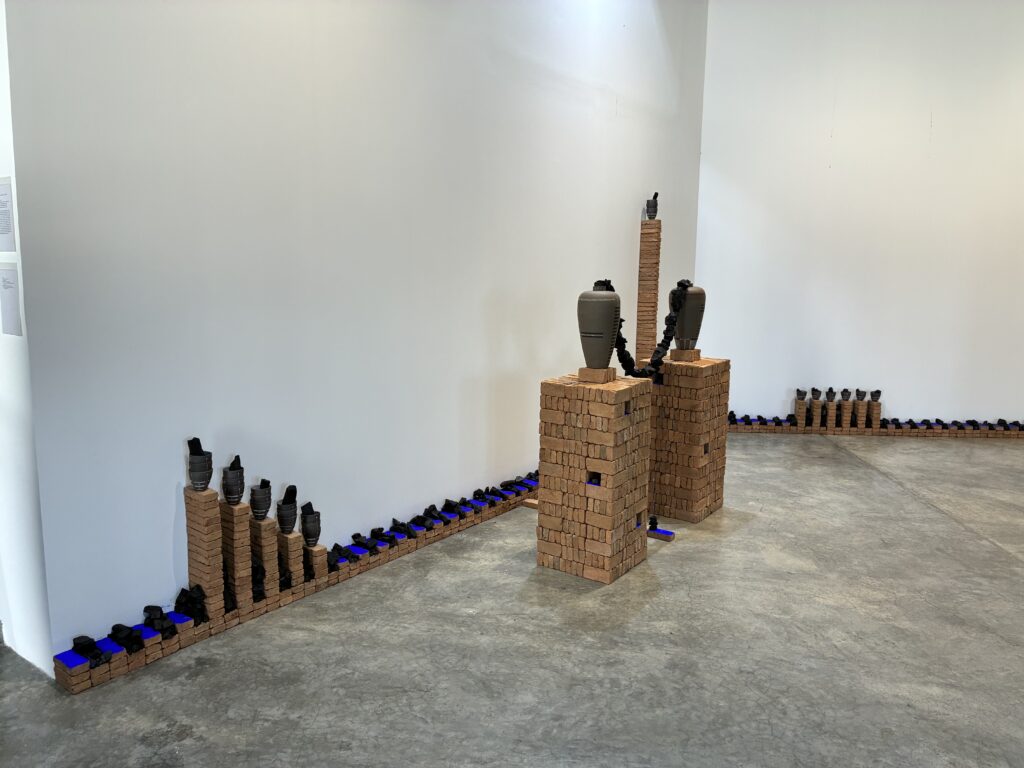 レンガを積み上げた台座の上に陶器の壺が置かれた作品が並ぶ展示室