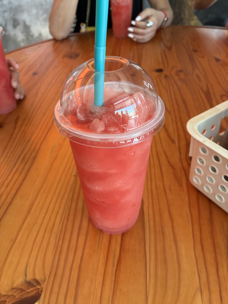 赤いスイカのスムージーが入った透明なカップ