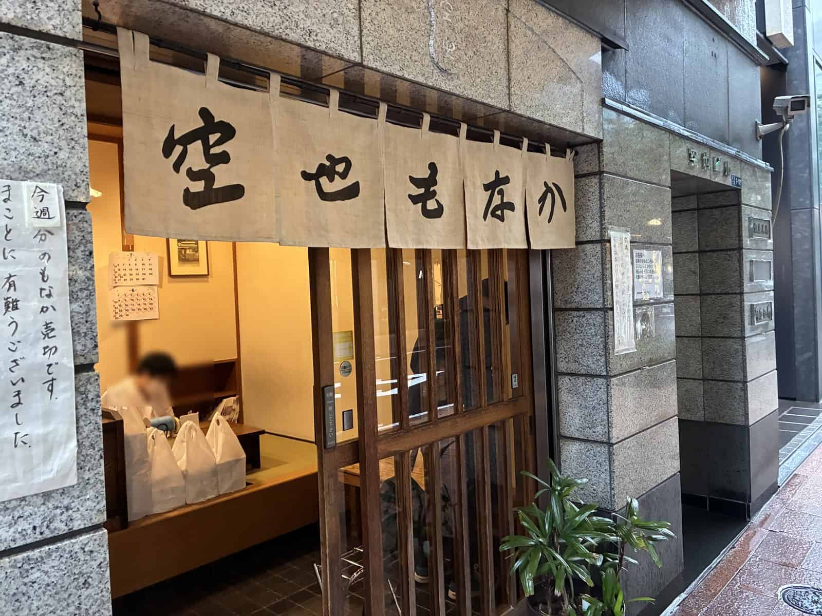 暖簾に「空也もなか」と書かれた空也の外観と、売り切れを知らせる張り紙