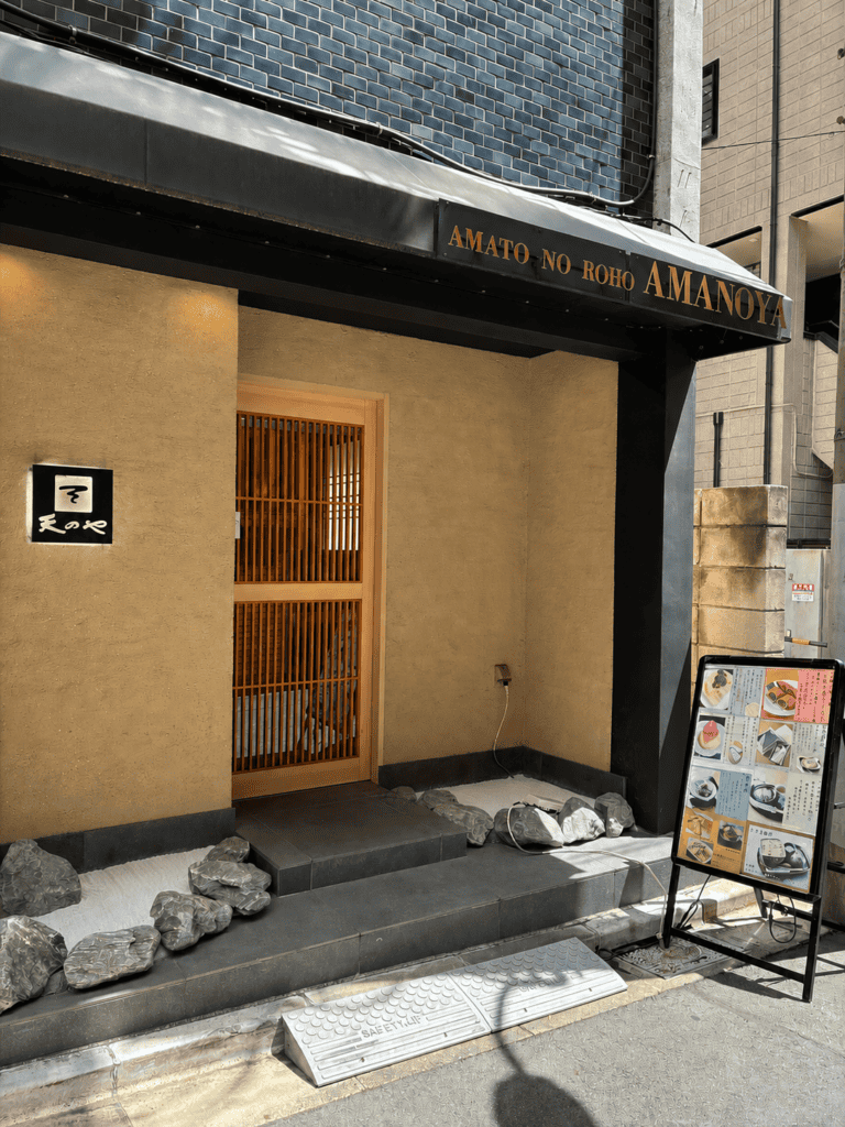 天のや麻布十番店の外観。木の格子戸と、AMANOYAと書かれた庇