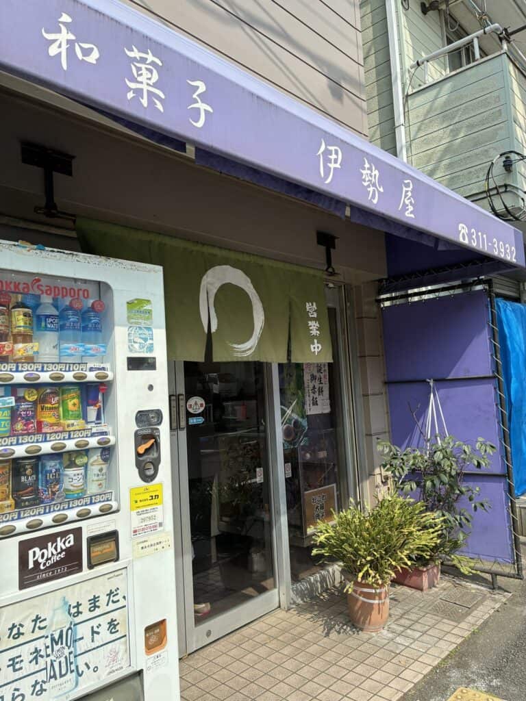 紫色の壁に和菓子 伊勢屋の看板が出た店舗の外観