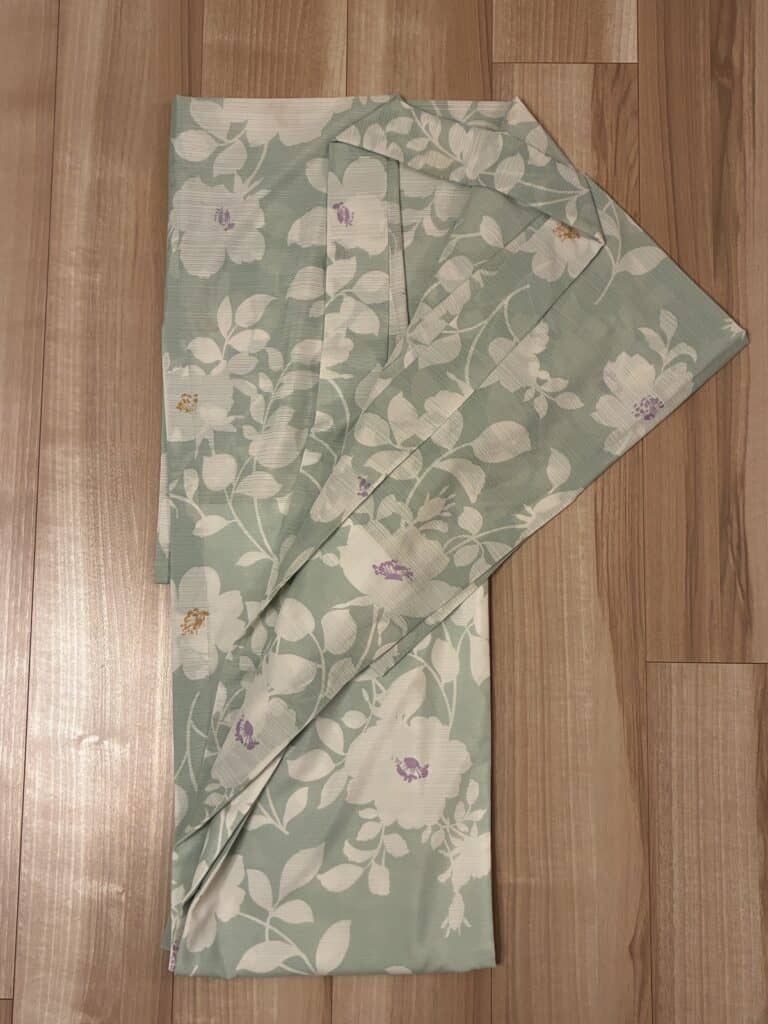 薄緑地に白い花が描かれた浴衣を畳んだ状態