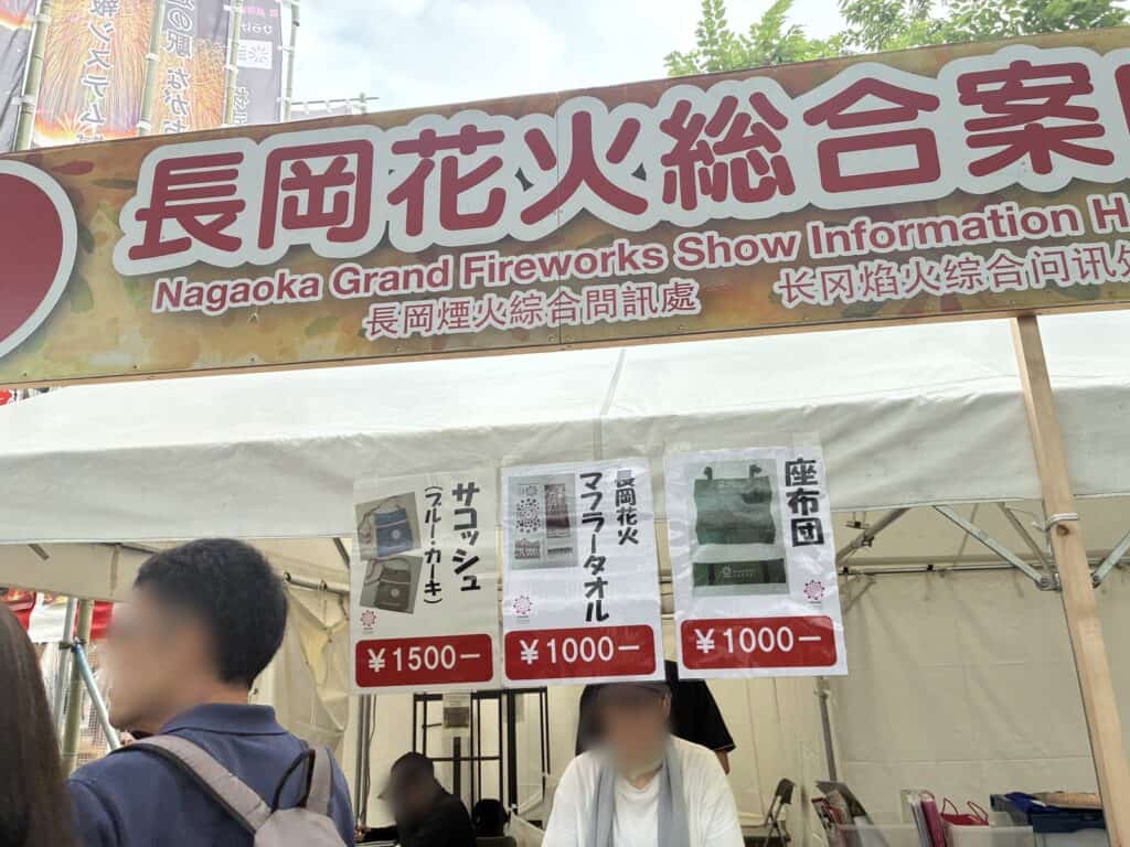 長岡花火総合案内所のテントと、座布団やタオルの価格表