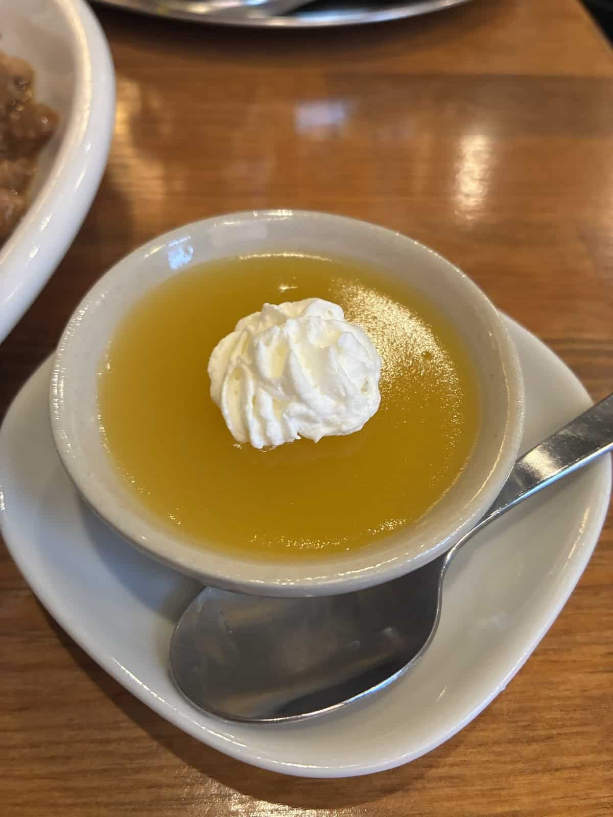 生クリームが乗ったオレンジ色のゼリーのデザート