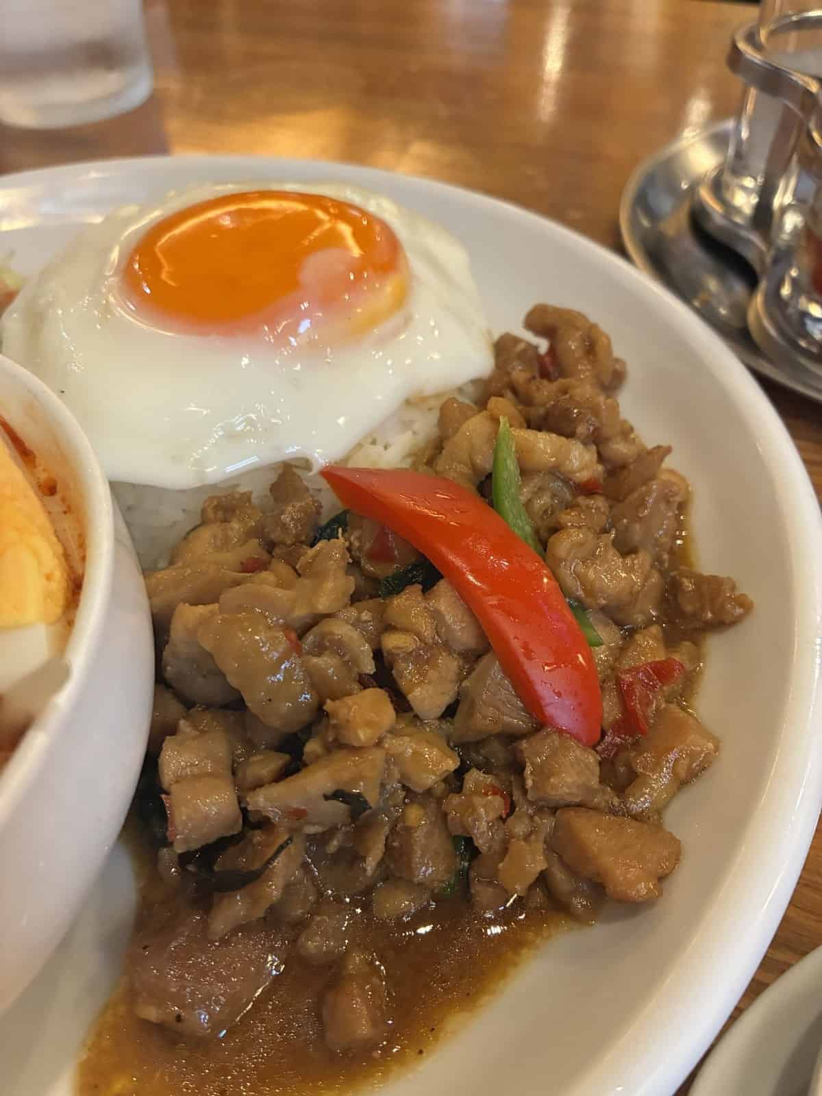 目玉焼きが乗った鶏ひき肉のガパオライスの寄り。赤唐辛子が見える