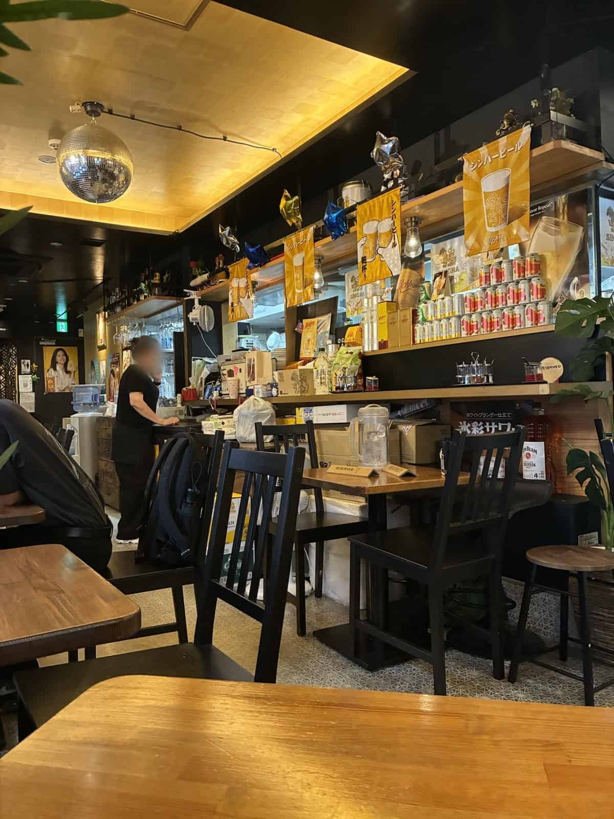 OCHABAR CAFEの店内。カウンターとテーブル席、タイビールの旗が下がっている