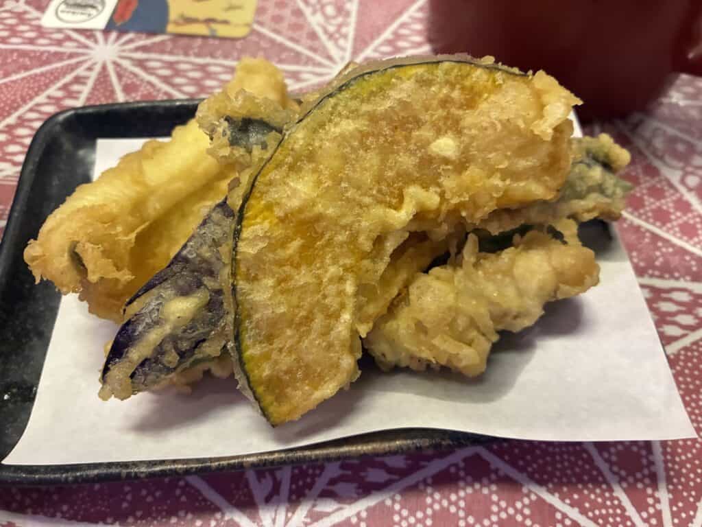 なすなどの野菜の天ぷらが皿に盛られている