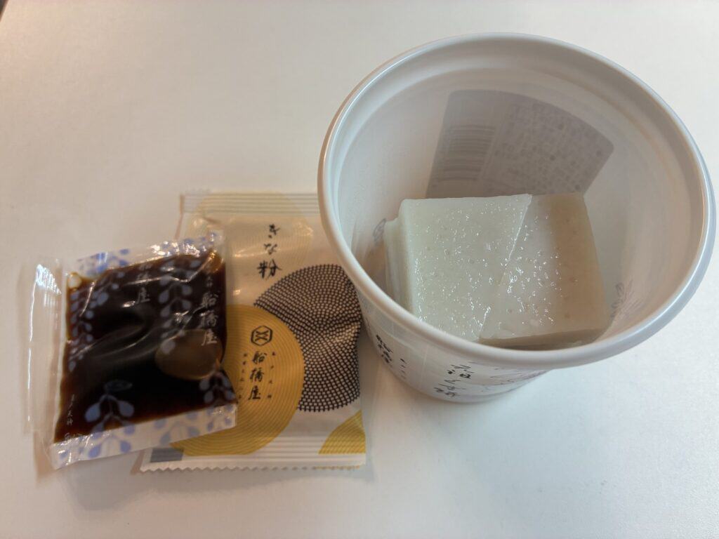 カップの中のくず餅と、取り出したきな粉と黒蜜の小袋