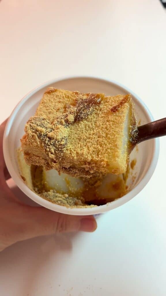 きな粉と黒蜜をかけたくず餅をスプーンですくい上げたところ