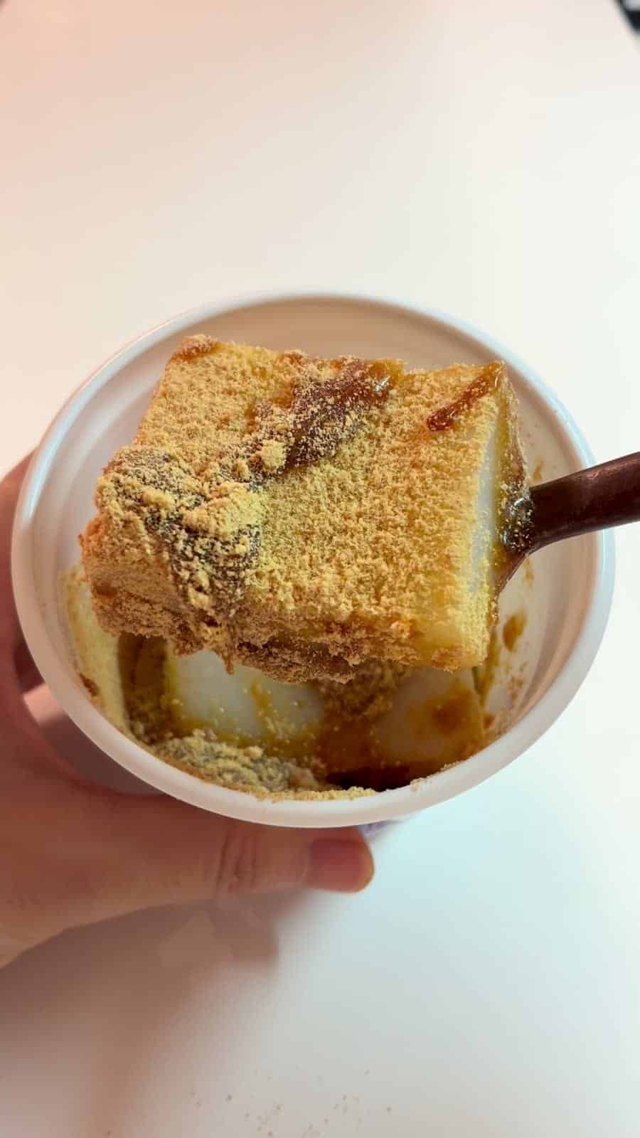きな粉と黒蜜をかけたくず餅をスプーンですくい上げたところ