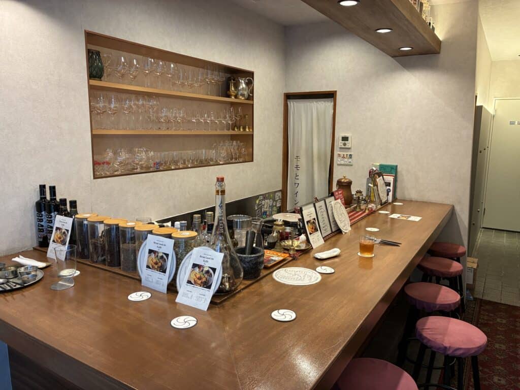 木のカウンターと丸椅子が並ぶ店内