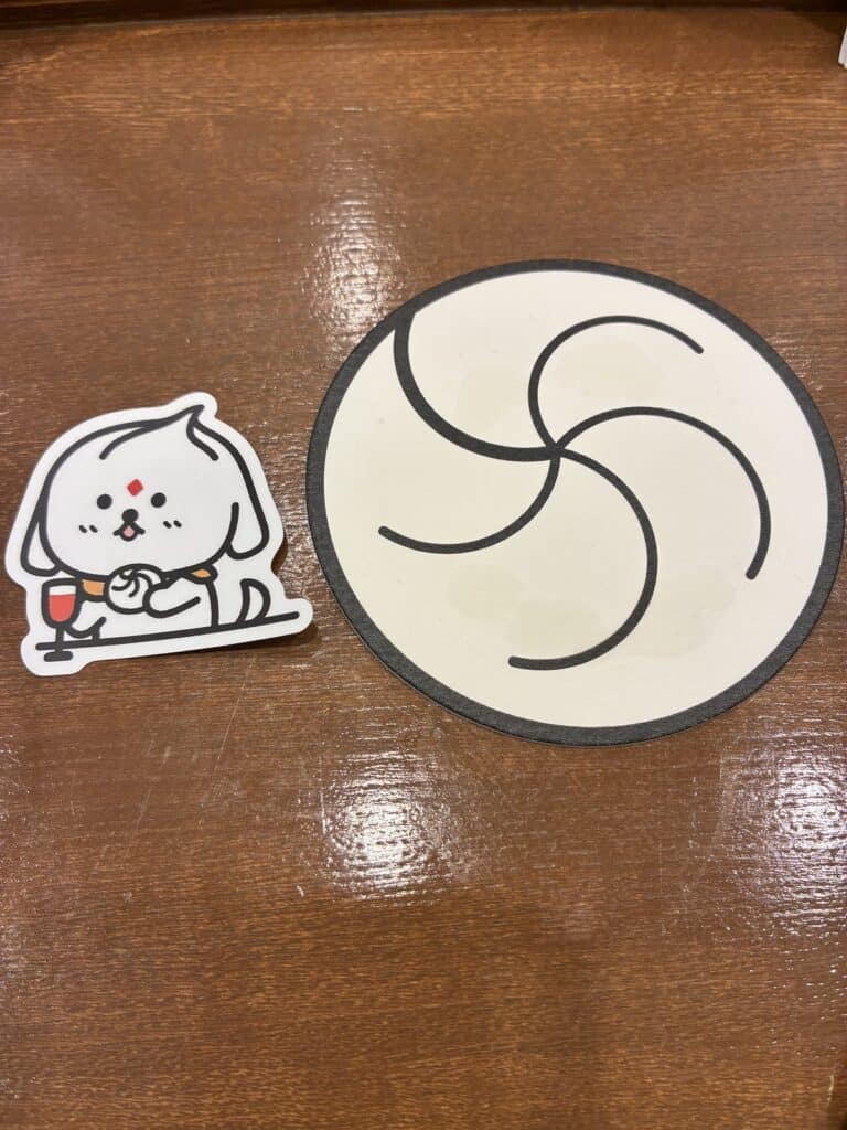 渦巻き模様のコースターと、オリジナルキャラクターのステッカー
