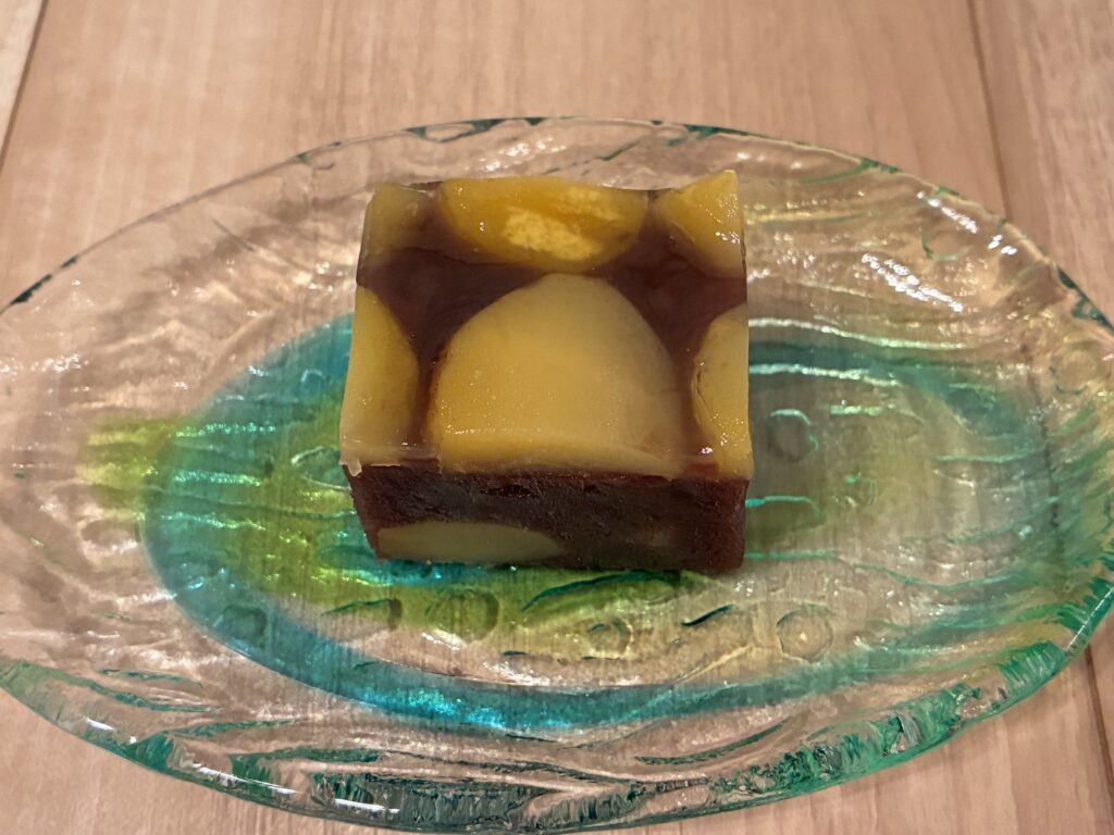 ガラスの皿に置かれた、栗の入った栗蒸し羊羹