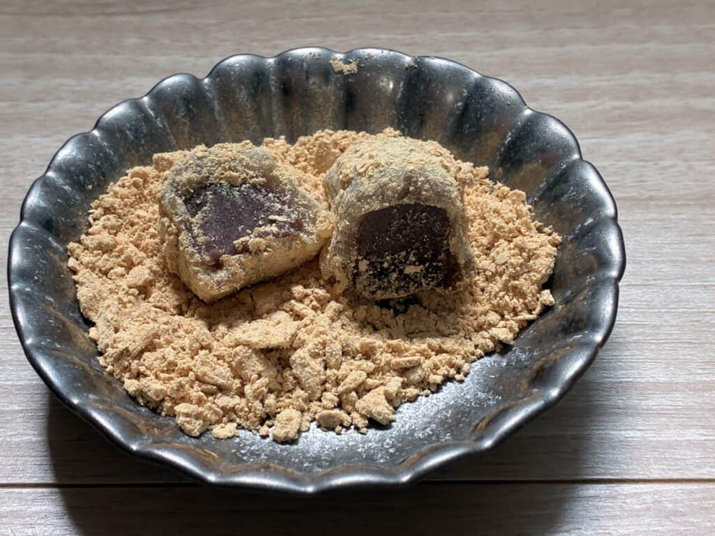 器に出した鶯もち2つ。たっぷりのきな粉の中に、断面からあんこが見える