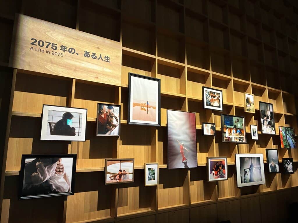 「2075年の、ある人生」と題された壁に、写真が並べて飾られている
