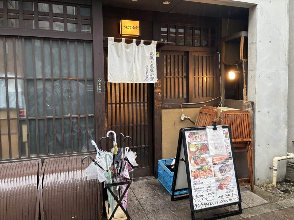 つばき食堂の外観。白い暖簾に「焼魚と家庭料理」と書かれている