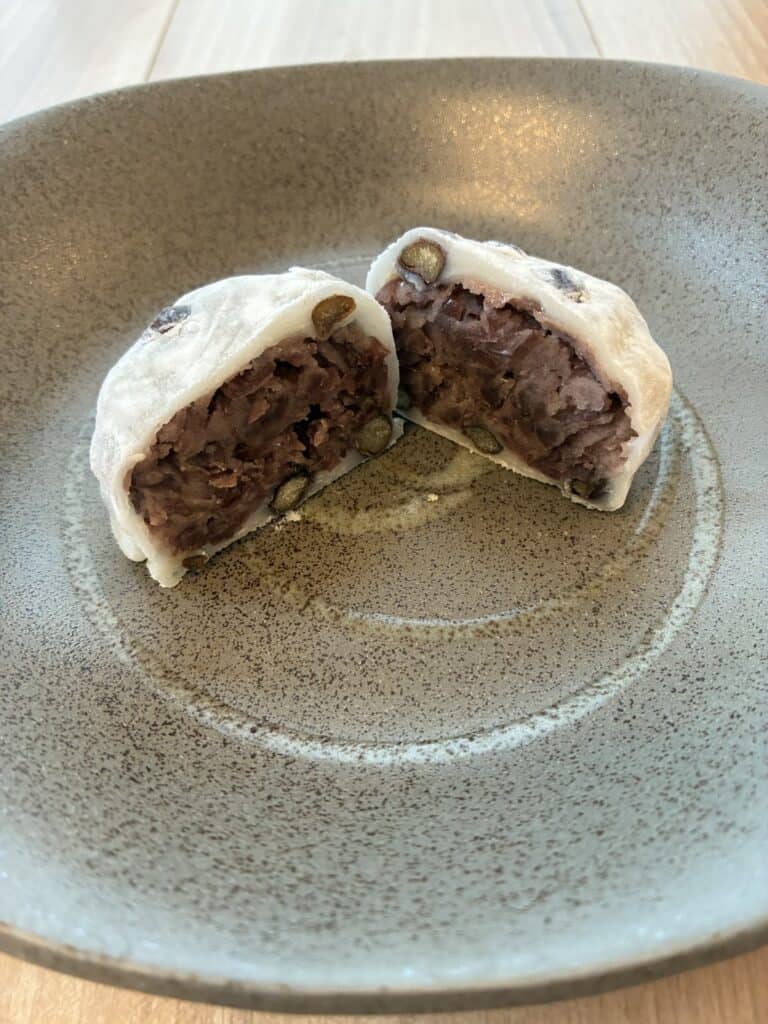 半分に切った豆大福の断面。つぶあんと、お餅の中の豆が見える